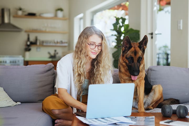 woman typing with dog